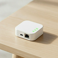 Small white device with Ethernet port on a wooden surface